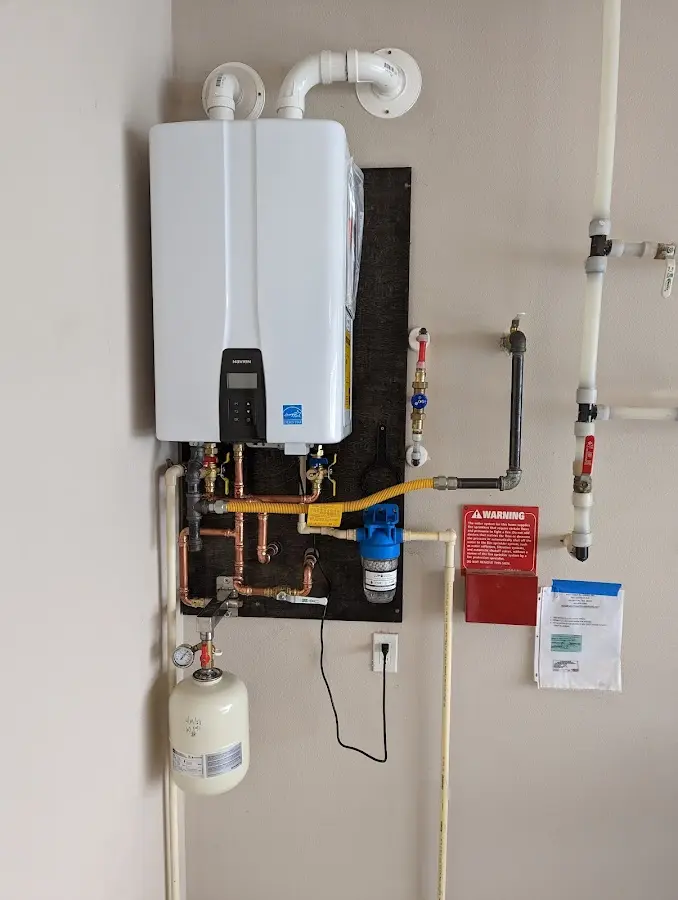 Professional plumber installing copper piping in a Bow home